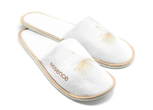 A pair of Essence hotel slippers, white color. A premium part of the ESSENCE hotel toiletries collection, natural and indulgent hotel amenities.